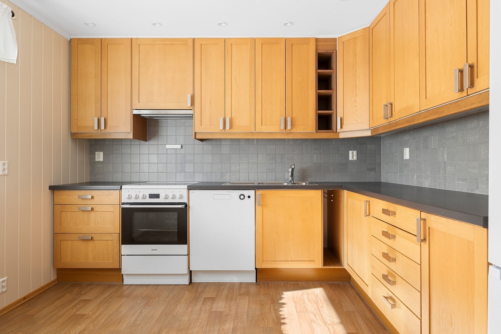 Pent og tidløst kjøkken med skap helt opp til taket og gode arbeidsflater. Spotter i taket. Galleribilde