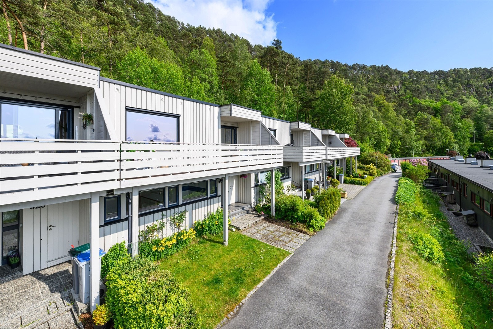 Man har et koselig bed for beplantning og en liten gressplen ved inngangspartiet. Galleribilde