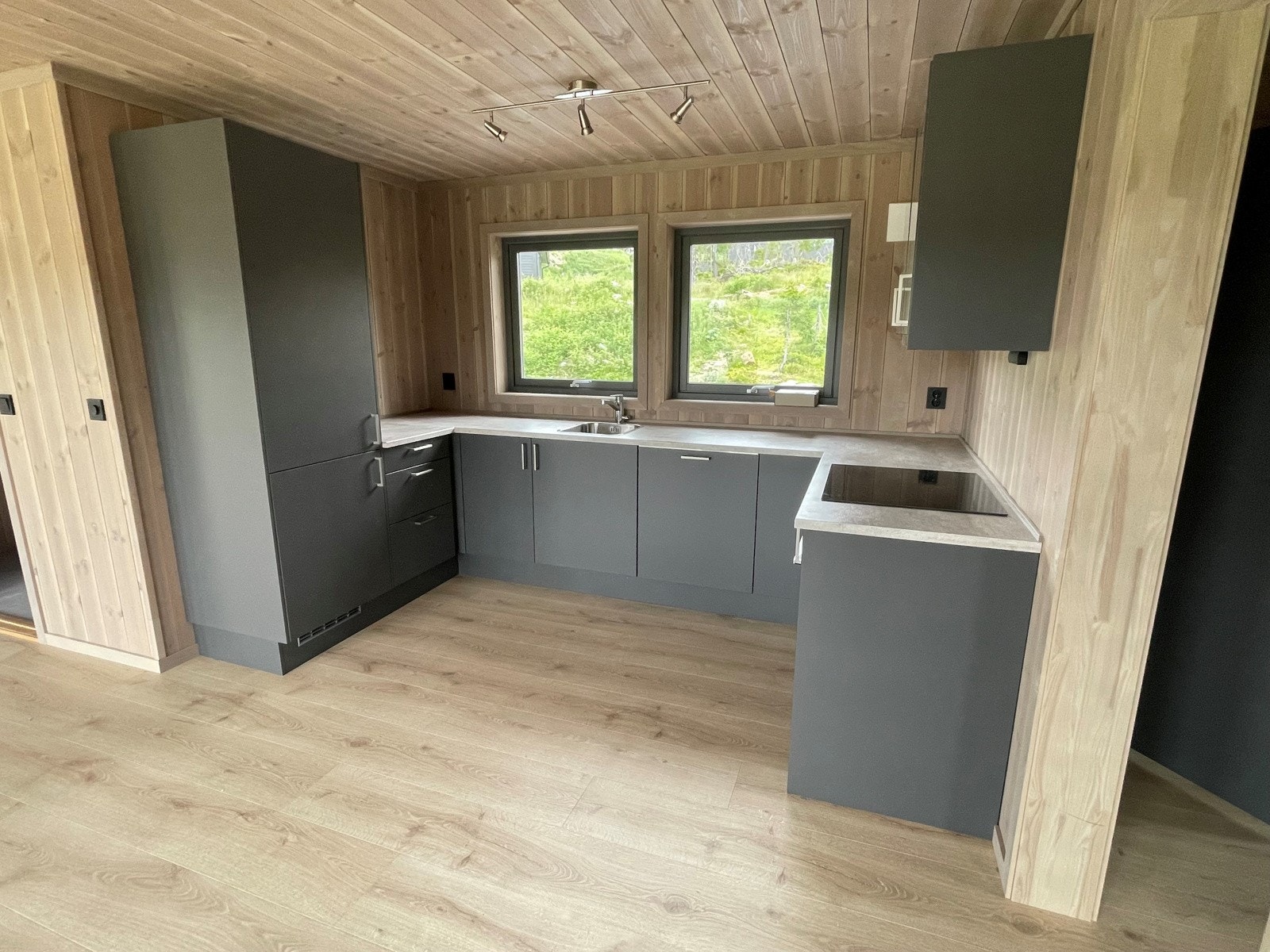 Pent og stilfullt kjøkken i U-form med integrerte hvitevarer Galleribilde