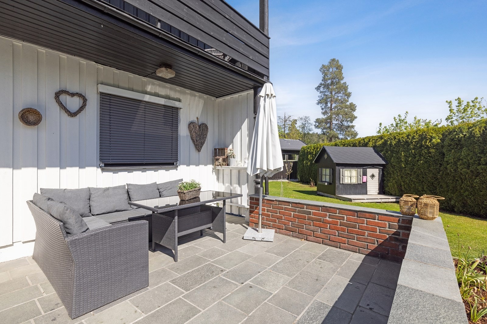 Fra gangen i 1. etasje er det utgang til en solrik uteplass og hage. Galleribilde