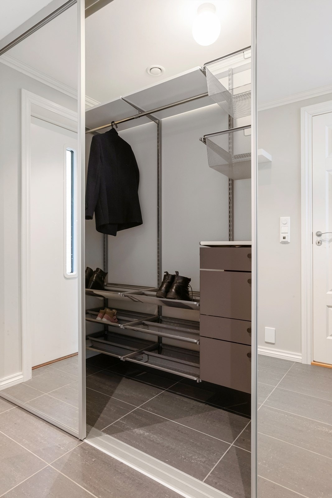 Entré med stor skyvedørsgarderobe/walk in-closet med speilfronter Galleribilde
