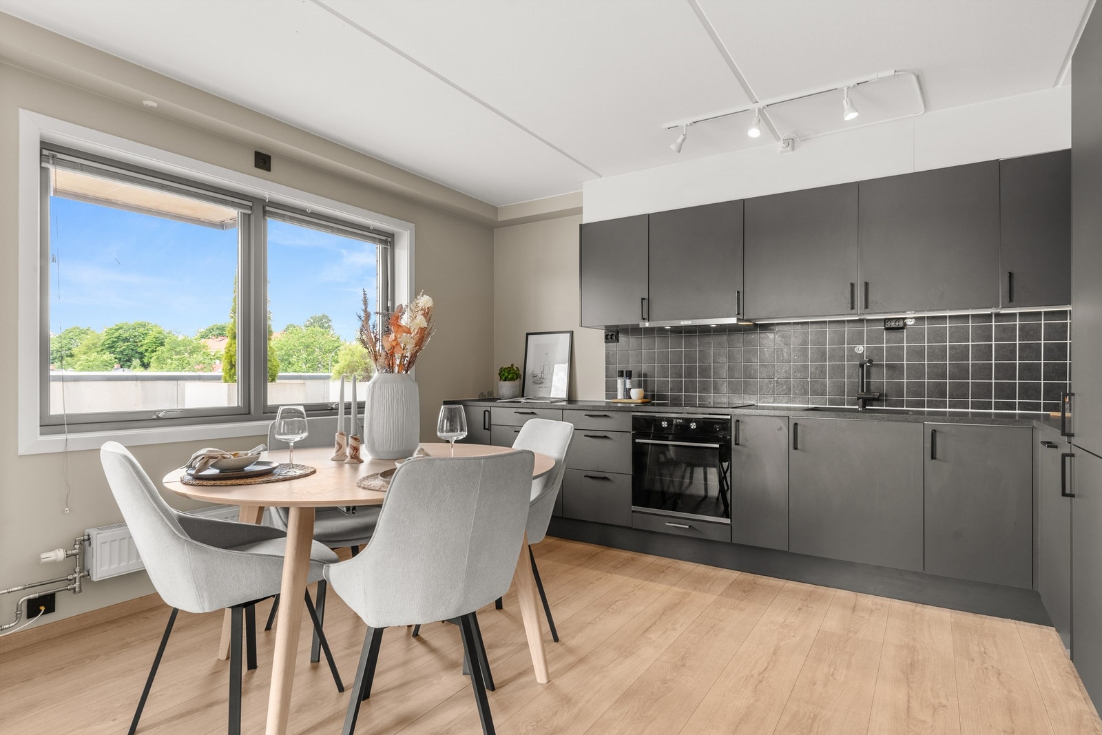 Kjøkkenet oppleves meget romslig. Kjøkkeninnredningen er tidløs med glatte fronter i grått og laminat benkeplate med nedfelt oppvaskkum. Galleribilde