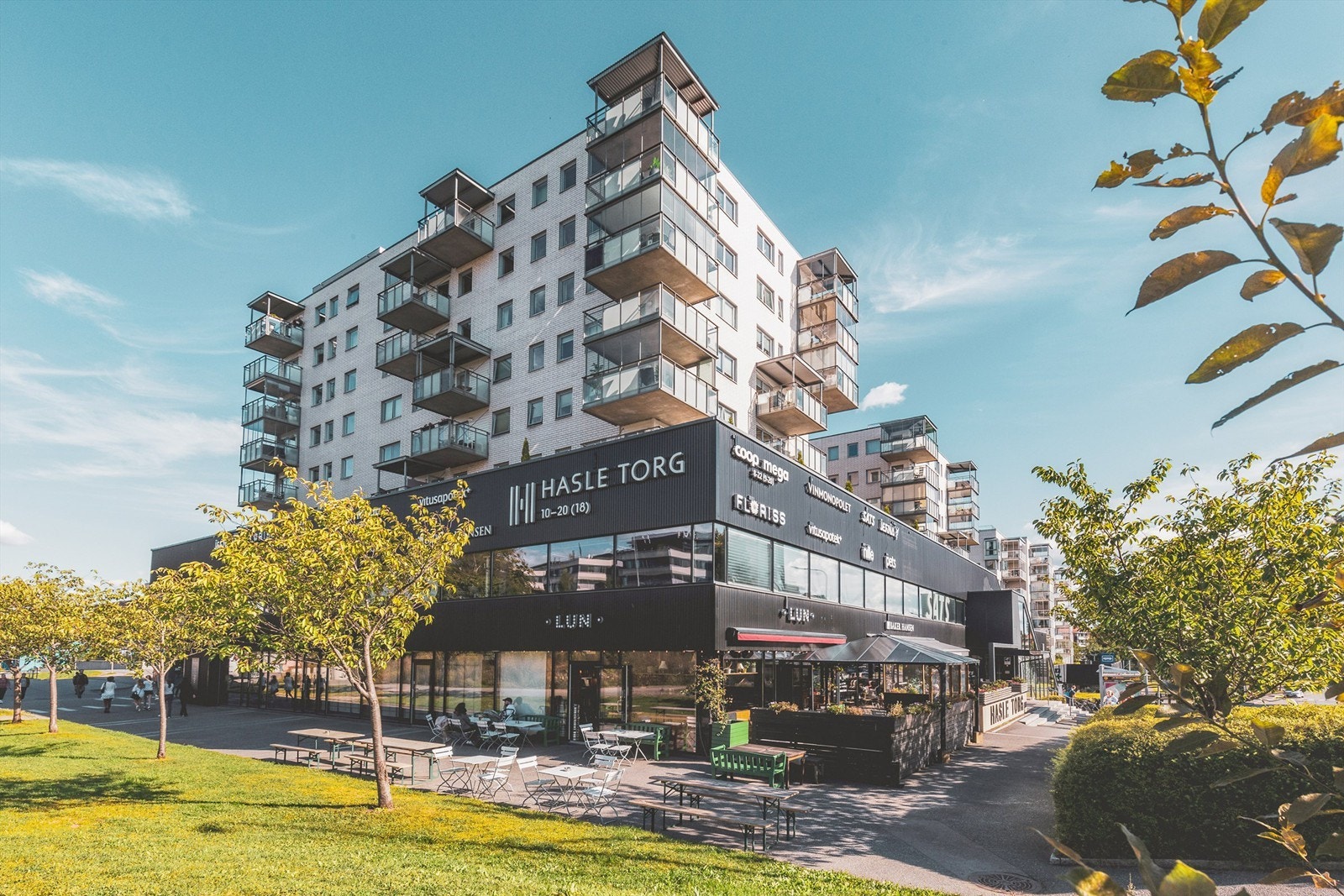 Kjøpesenter under leilighetskomplekset med Coop Mega, Baker Hansen, Vitus Apotek, Vinmonopol, Nille, bydelskroen LUN, Floriss blomster, treningssenterkjeden Sats, Jernia m.m. Galleribilde