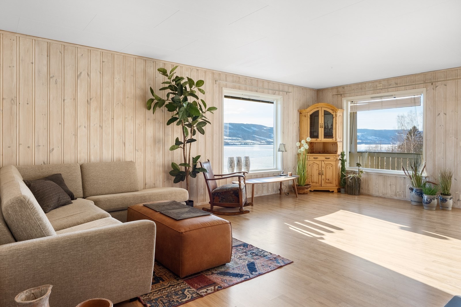 På stuen er det laminatgulv, panelerte vegger og plater i himling. Galleribilde