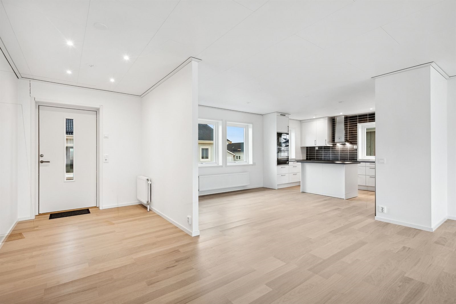 Lys og åpen entré gir et godt første inntrykk av boligen. Entréen er belyst med downlights og det er også radiator for oppvarming på siden. Galleribilde