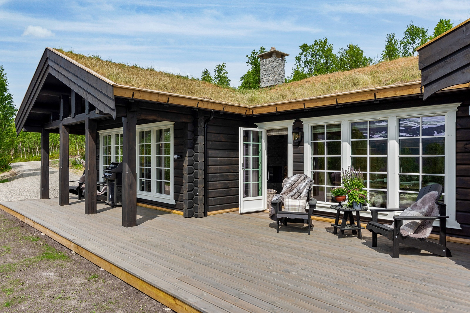 Hytta har et harmonisk eksteriør som legger seg fint i terrenget.
Bildet viser en variant av samme modell der det er gjort tilpasninger av kunde. Galleribilde