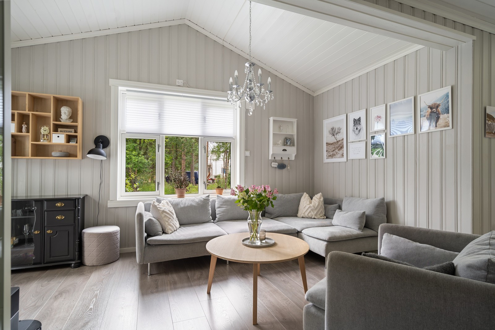 Stuen har et moderne uttrykk med rene, slette overflater og tidløst fargevalg.