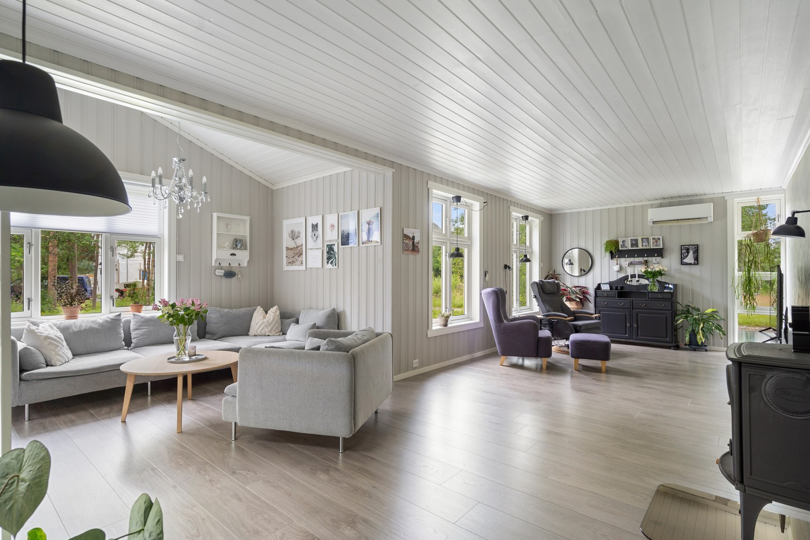 Velkommen inn i den åpne og trivelige stua, med store vindusflater som slipper inn rikelig med dagslys.