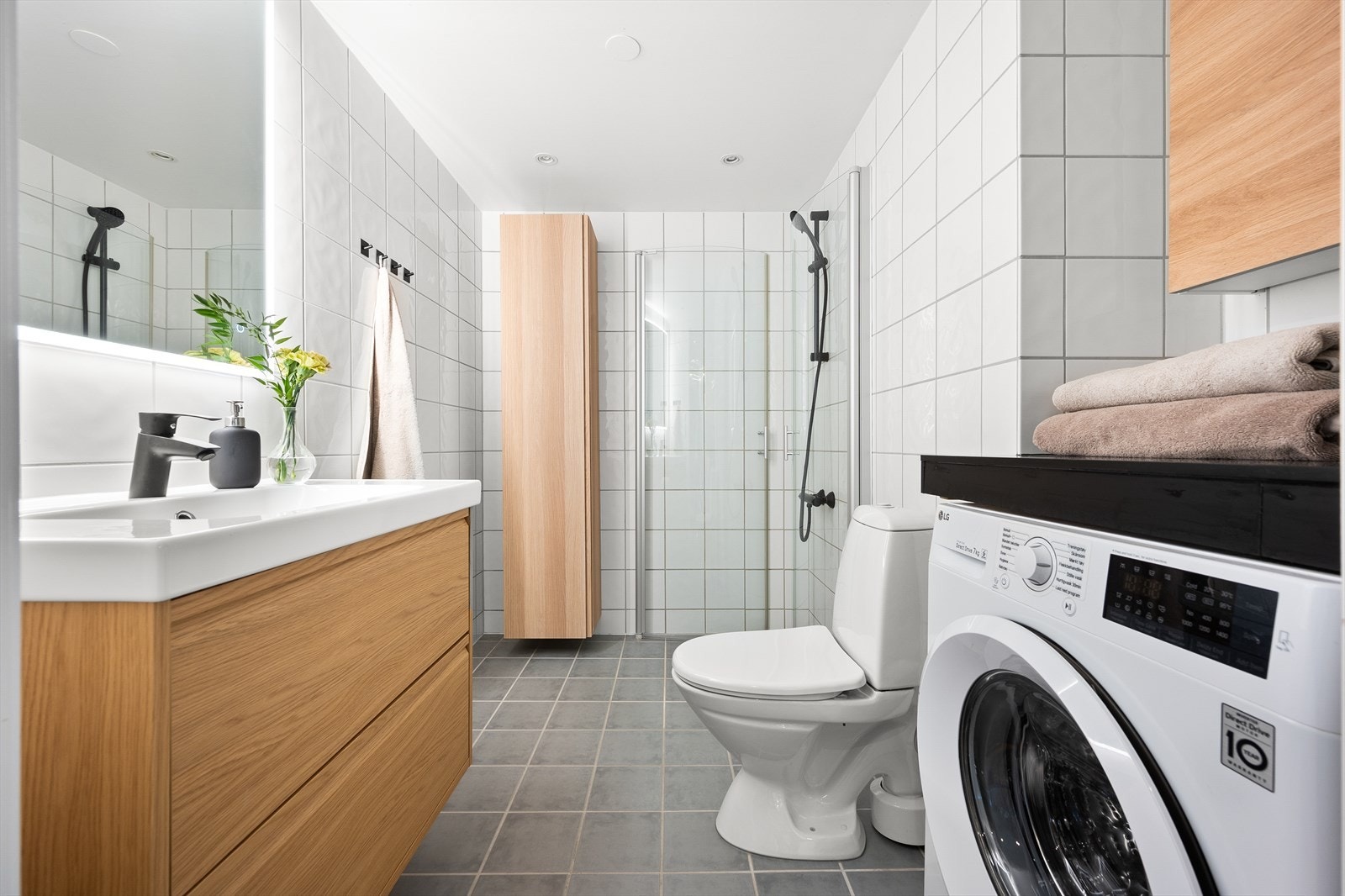 Pent flislagt baderom med elektrisk gulvvarme. Baderommet har himling med malte plater og innfelt downlights. Det er innredet med klosett, servant nedfelt i innredning, speil m/lys og dusjhjørne med svingbare glassdører. Galleribilde