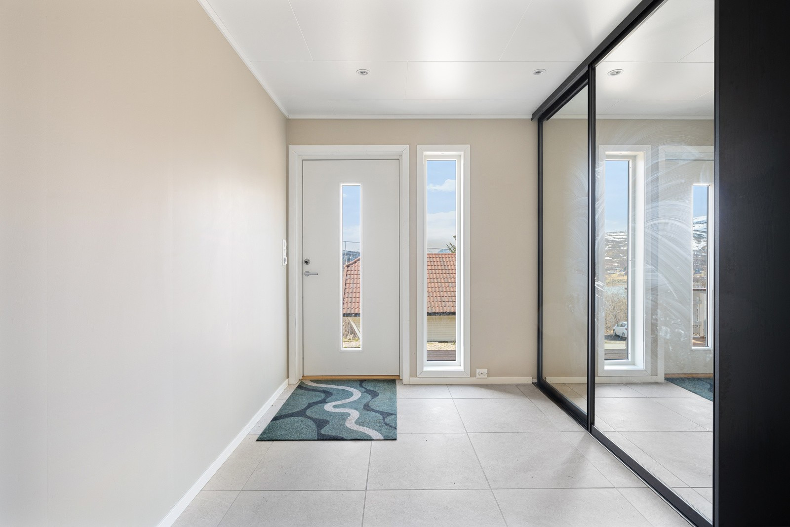 Velkommen inn! Romslig entré med lekre fliser på gulv, gulvvarme og stor skyvedørsgarderobe.