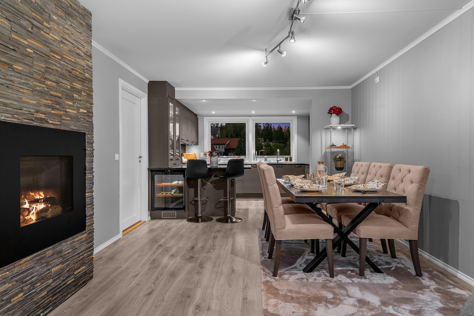 Praktfull stue fremstår som sjarmerende i delikat fargevalg. På gulvet er det lagt laminat, som strekker seg sømløst inn i kjøkkenet. Det er lagt stilig skifersteinkledning rundt integrert gasspeis for ekstra stemning! Galleribilde