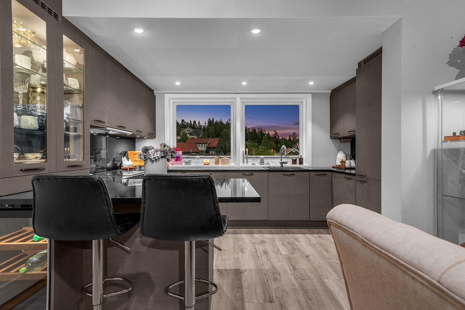 Innredningen fra Sigdal er designet med slette fronter, et større vitrineskap med belysning, sorte benkeplater i granitt, belysning og sorte glassplater over benk, nedfelt oppvaskkum og 1-greps blandebatteri! Galleribilde