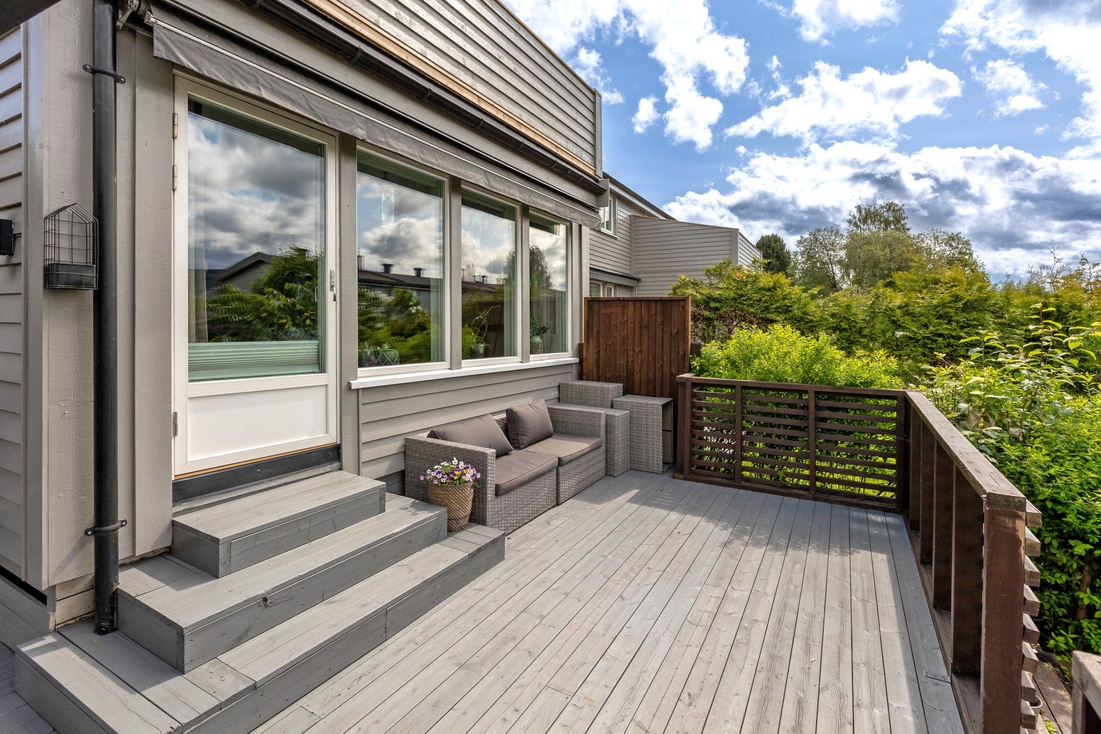 Fra stuen er det utgang til hyggelig terrasse med nybeiset gulv og trapp ned til den frodige hagen. Galleribilde