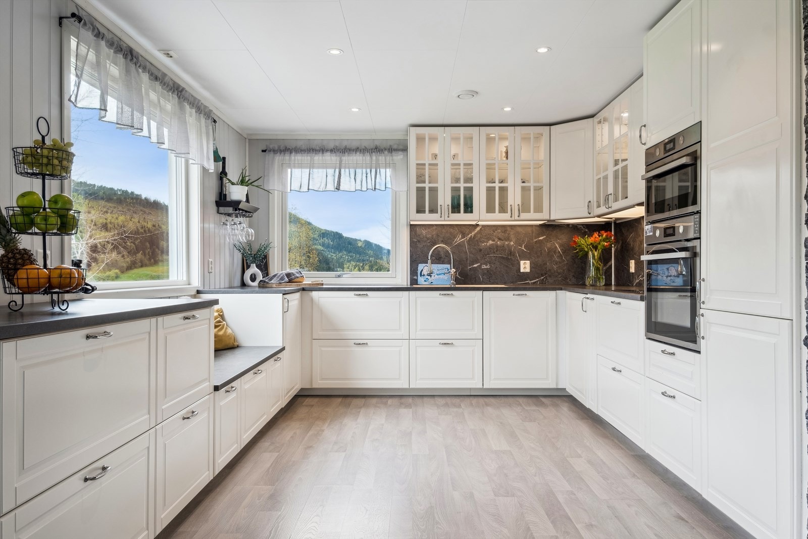 Stilrent kjøkken med integrerte hvitevarer og rikelig med benkeplass Galleribilde