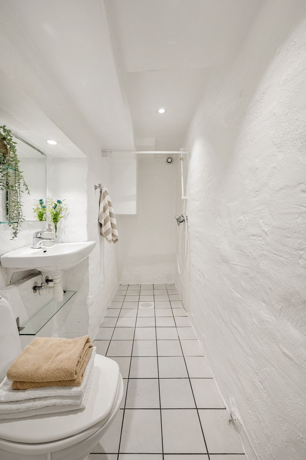 Bad med flislagt gulv med varme og downlights i himling. Galleribilde