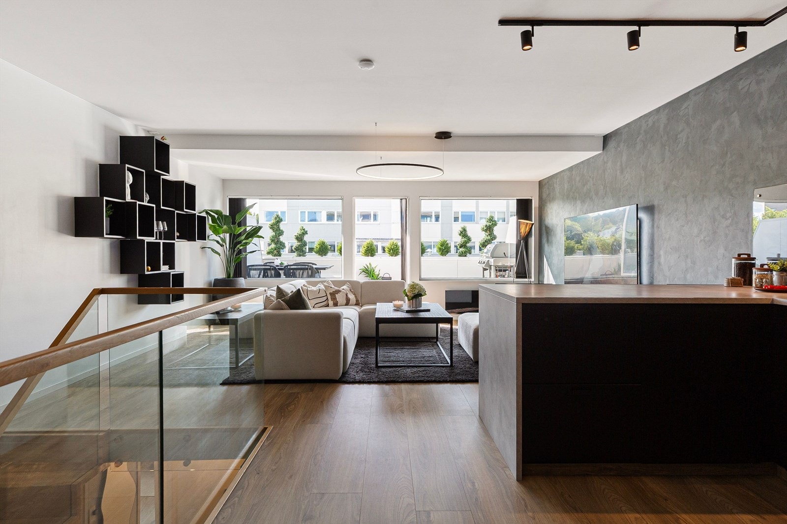 Stuen nyter god naturlig belysning fra store vindusflater mot verandaen. Galleribilde