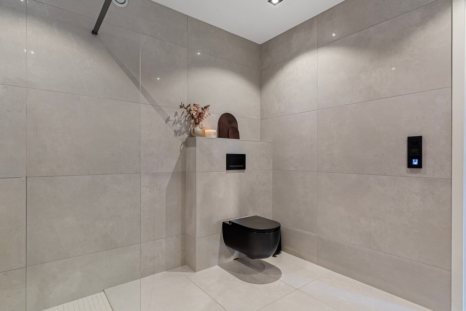 Badet består av glassvegg i dusjsonen med svarte detaljer, waterfall dusj, opplegg for vaskemaskin, 120 sort kommode med høyskap nytt fra 2022, dimbar belysning i speil, og varmekabler i gulv. Badet har fått tilstandsgrad 1, ifølge takstmann. Galleribilde