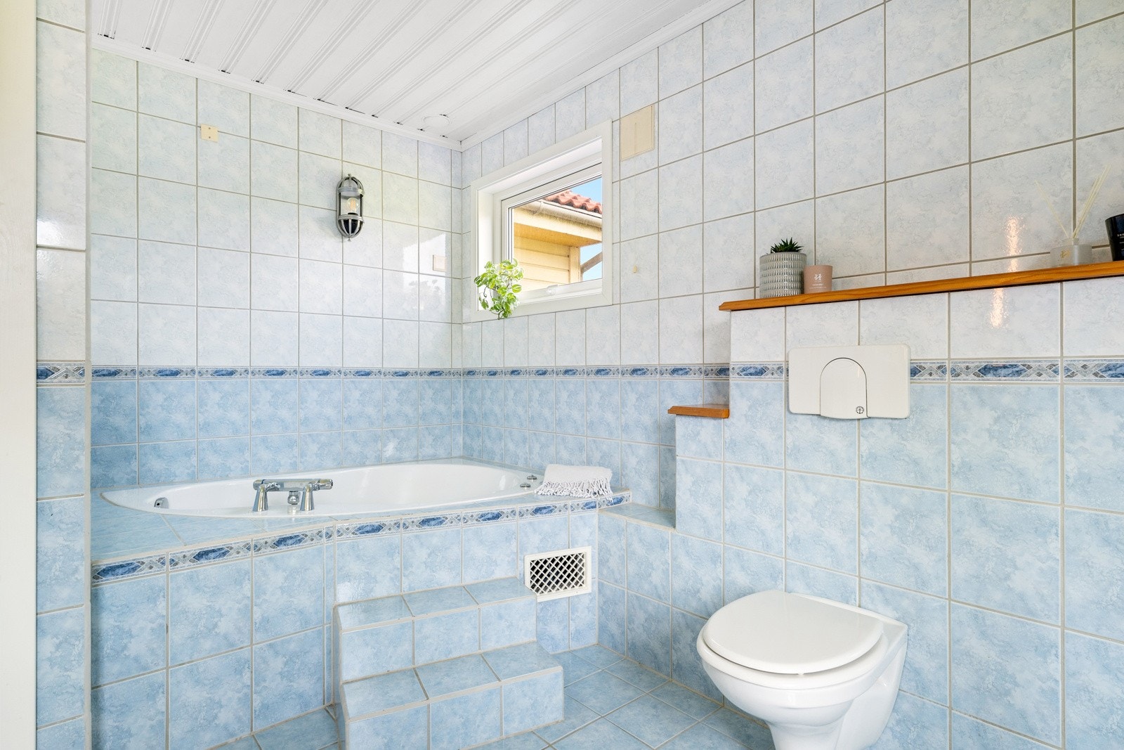 Videre har badet et vegghengt toalett, et innfliset badekar og et dusjkabinett. Galleribilde