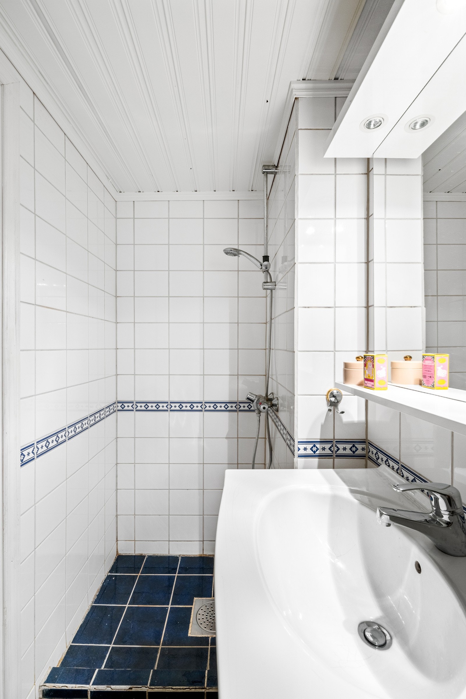 Innredningen har hvite fronter og består av en heldekkende servant på en skapseksjon, et veggskap og et speil med belysning. Galleribilde