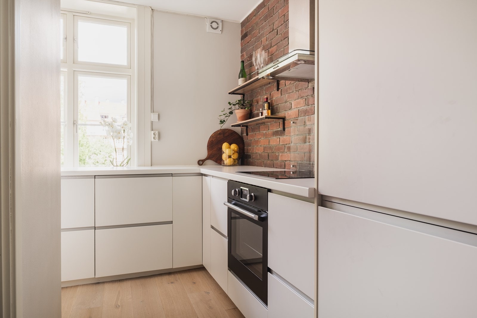 Innredet med integrert kjøl/fryseskap, stekeovn, platetopp, oppvaskmaskin og vaskemaskin Galleribilde