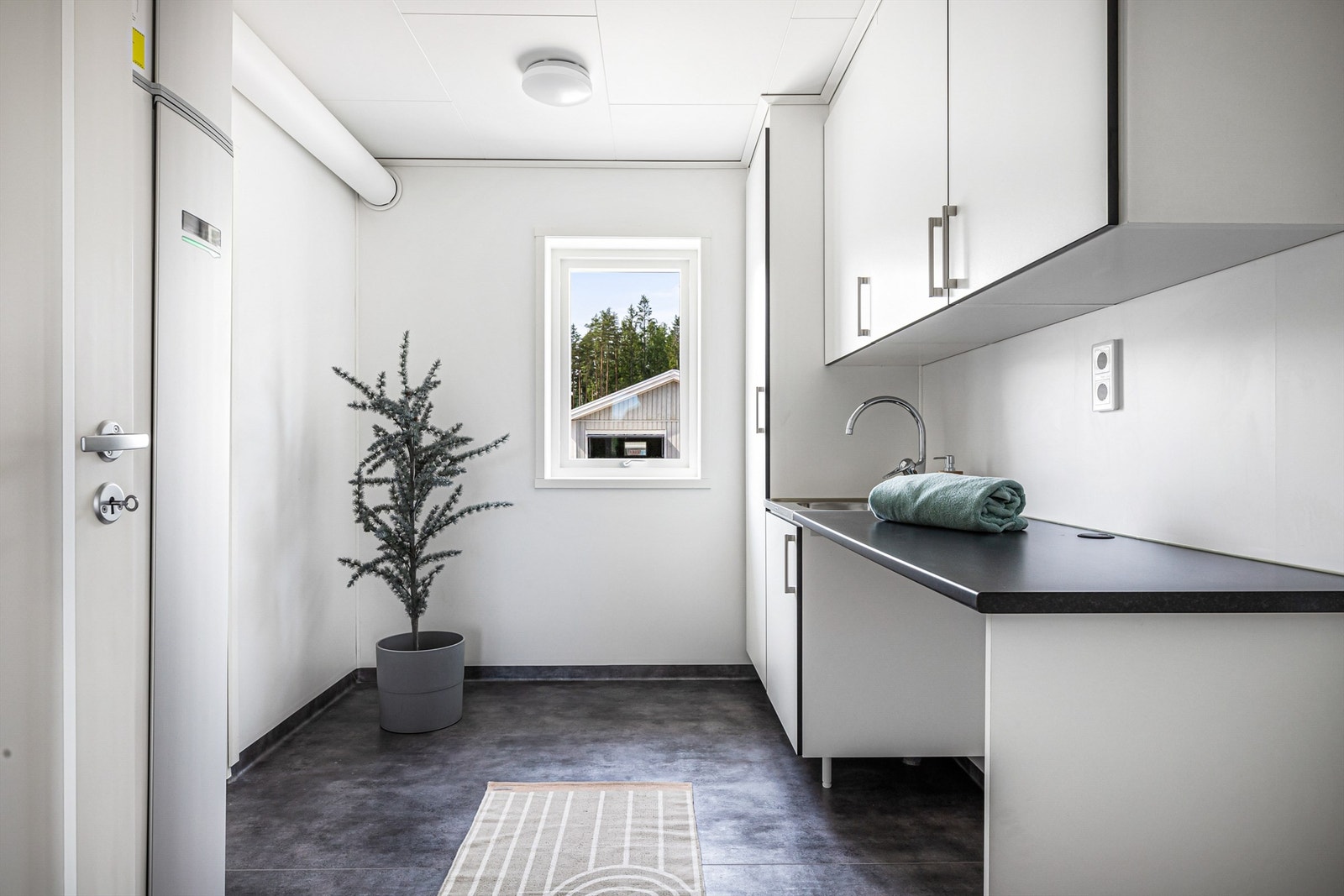 Innenfor kjøkkenet er det et praktisk vaskerom med med utgang til gårdsplassen. Galleribilde