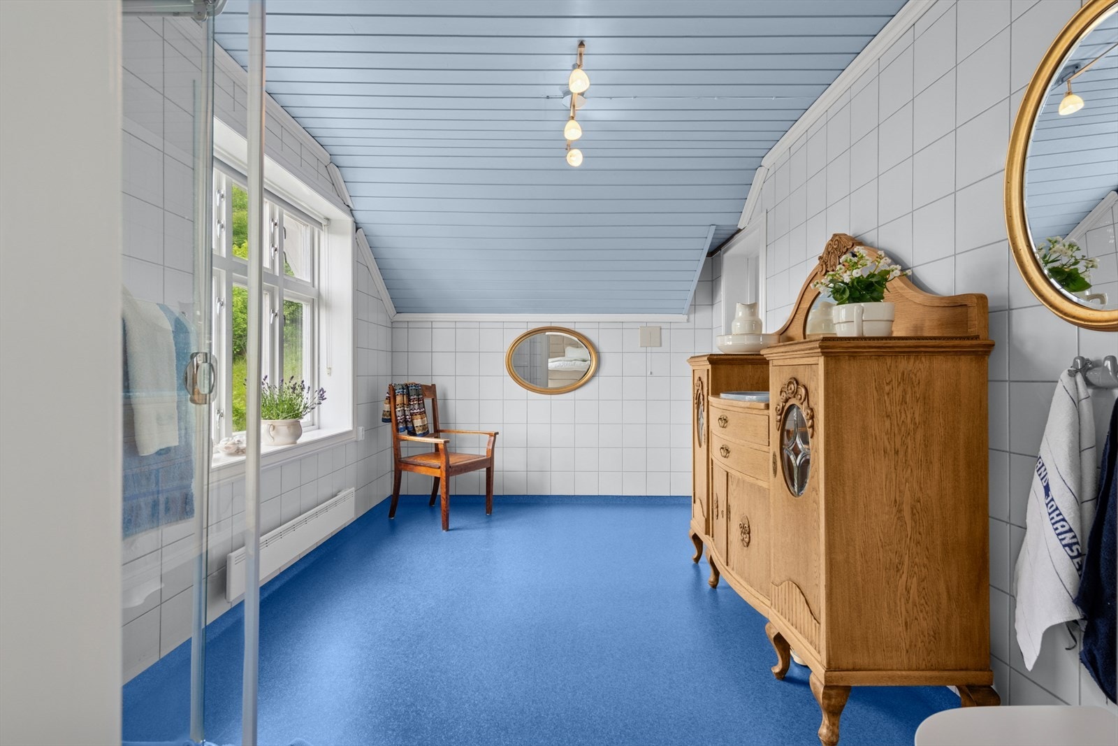 Badet er innredet med toalett, dusjkabinett og servant med underskap og speil. Galleribilde