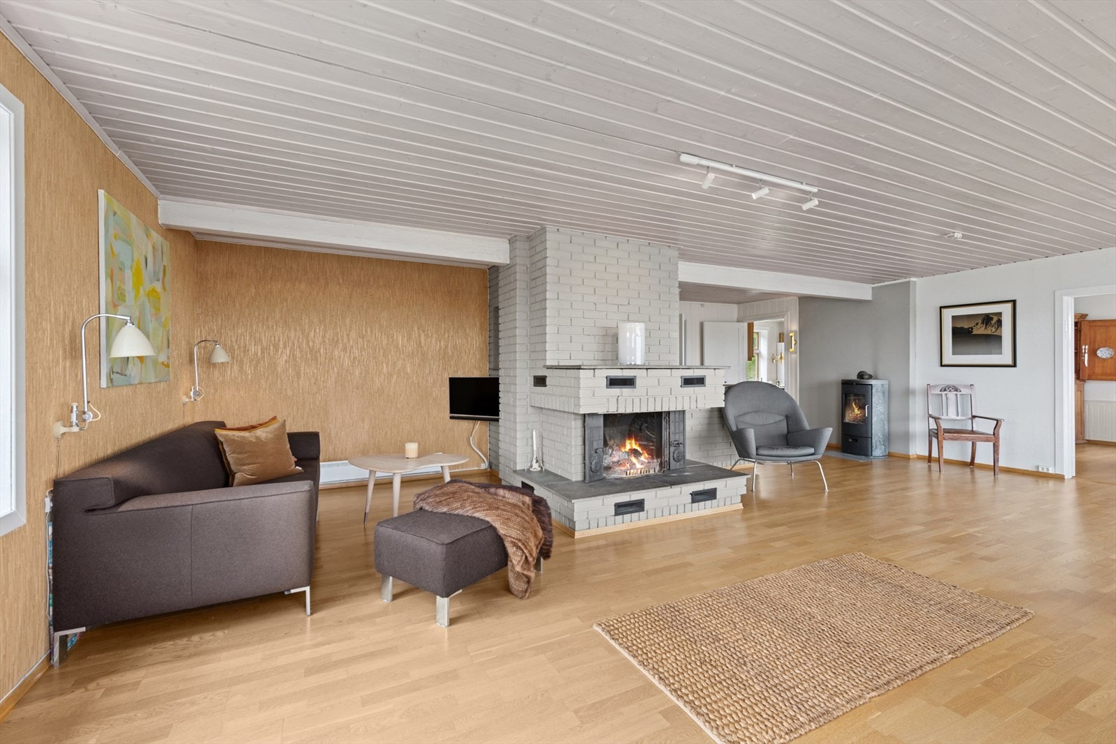 Stuen har både plassbygd åpen peis og en vedovn for både hygge og varme på kalde dager. Galleribilde