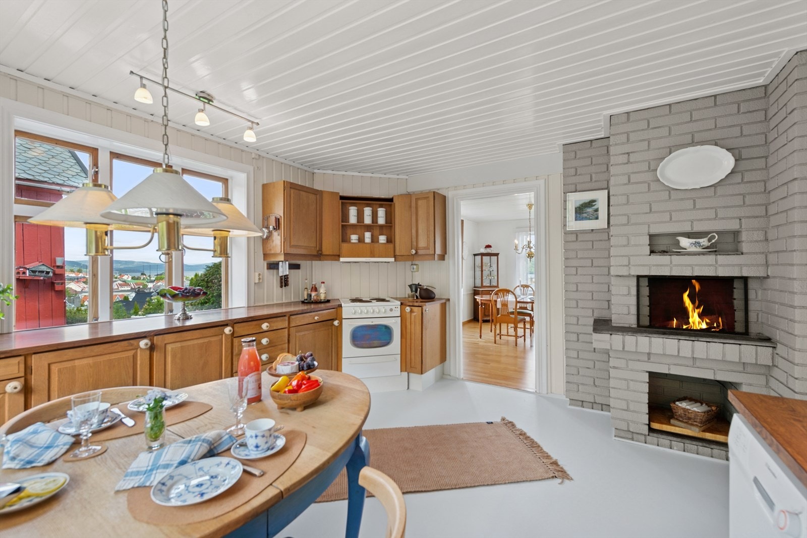 Rommet har en plassbygd åpen peis i hjørnet, samt god plass til kjøkkenbord. Galleribilde