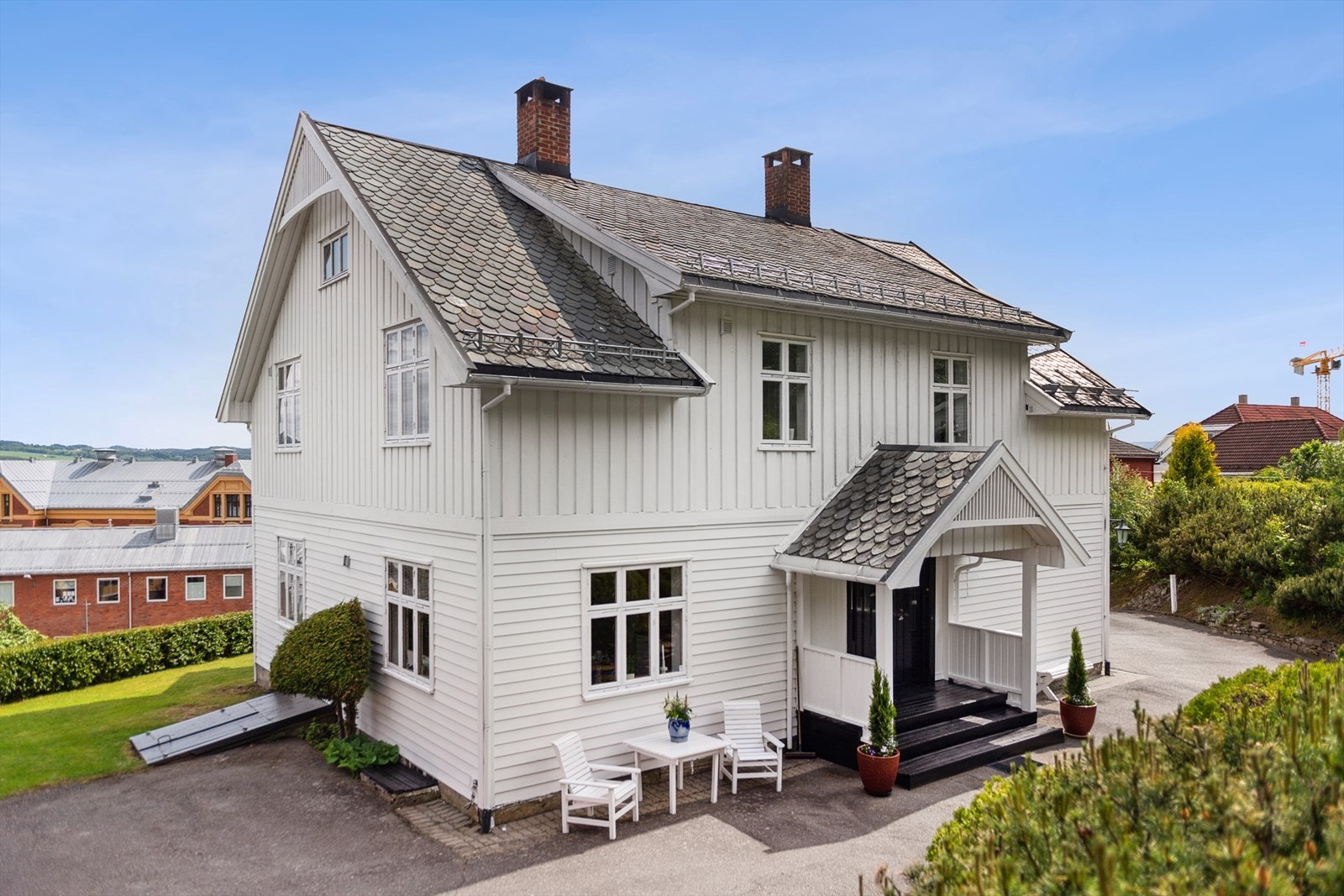 Asfaltert gårdsplass med et koselig inngangsparti som er overbygd. Galleribilde