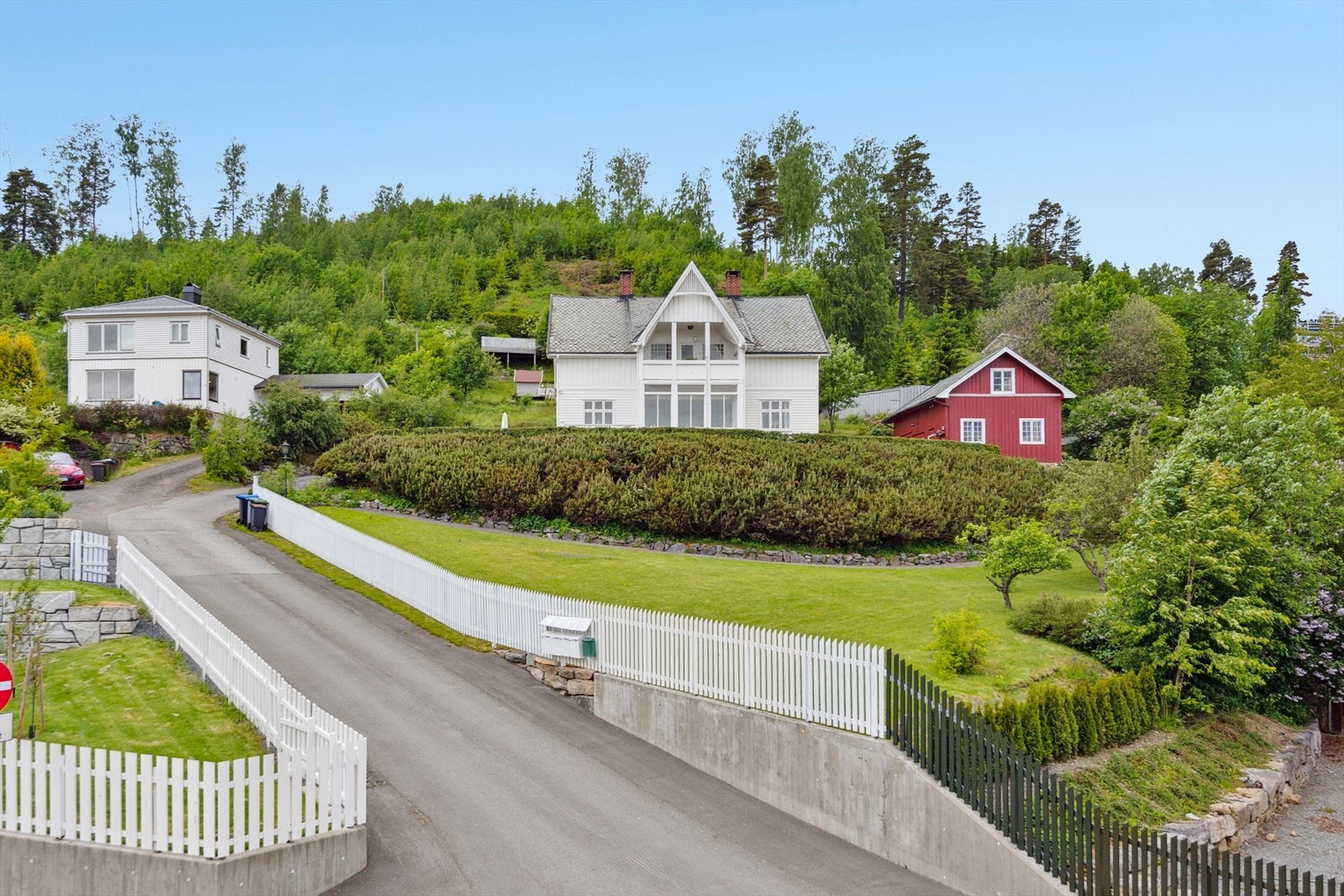Asfaltert bilvei opp til romslig gårdsplass. Galleribilde