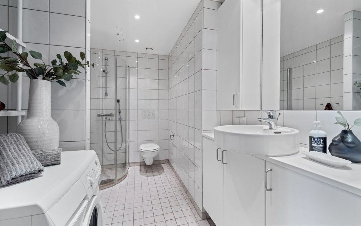 Flislagt baderom med opplegg for vaskemaskin. Galleribilde