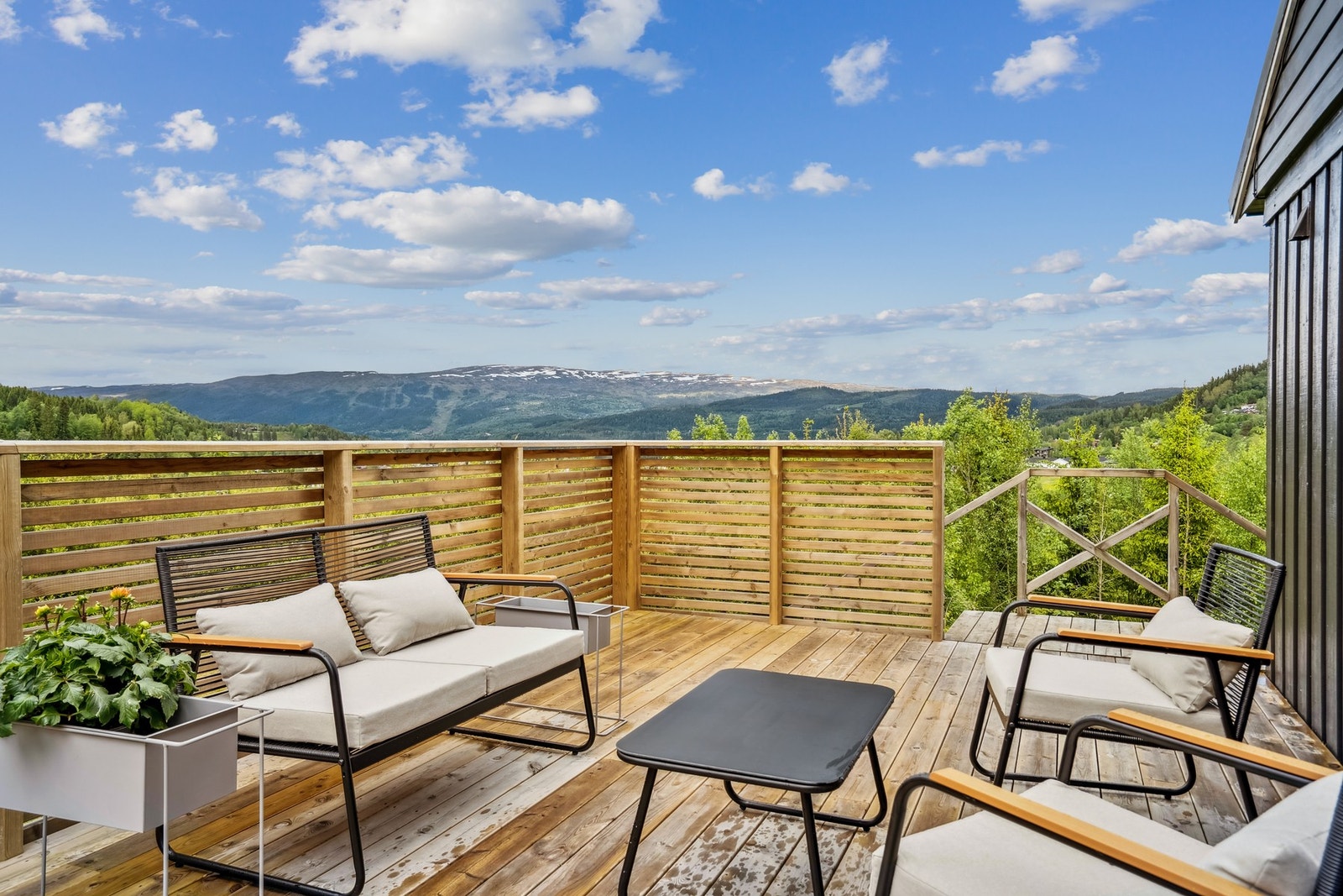 Verandaen er stor og innbydende, med plass til både spisegruppe og lounge - her kan du nyte en flott utsikt mot naturen og de omkringliggende fjellene. Galleribilde