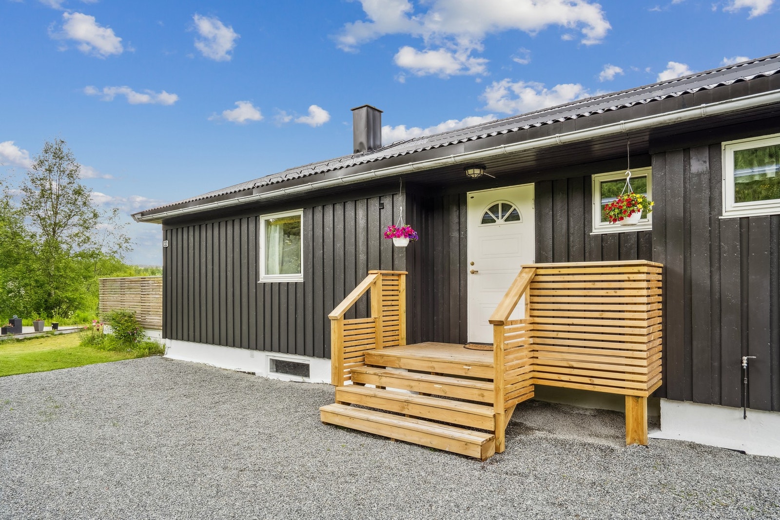 Den romslige, gruslagte gårdsplassen foran huset og garasjen gir svært gode parkeringsmuligheter - perfekt for både hverdag og besøk. Galleribilde