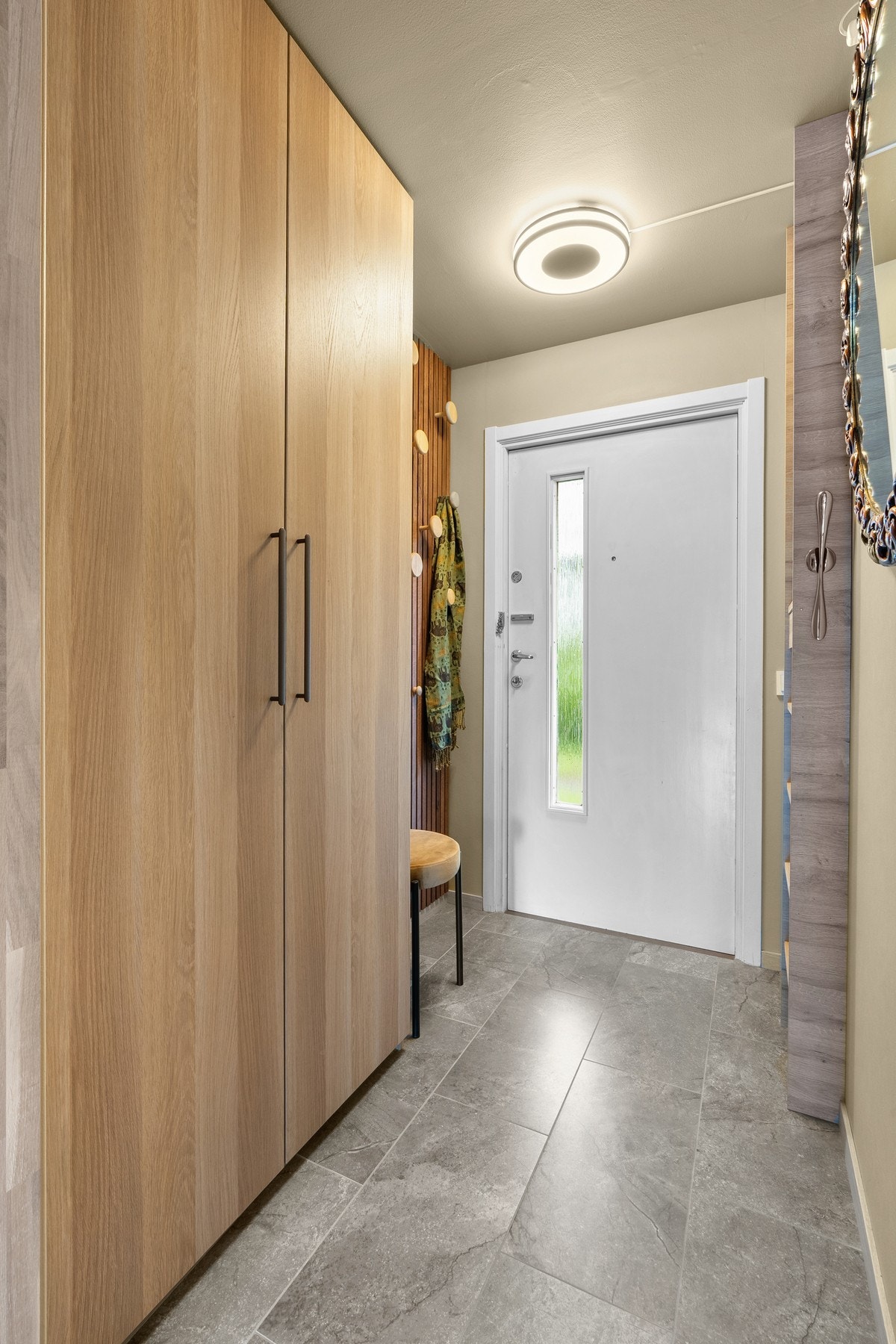 Entreen har flislagt gulv og plass til å henge fra seg ytterklær, både på knagger og i garderobeskap. Galleribilde