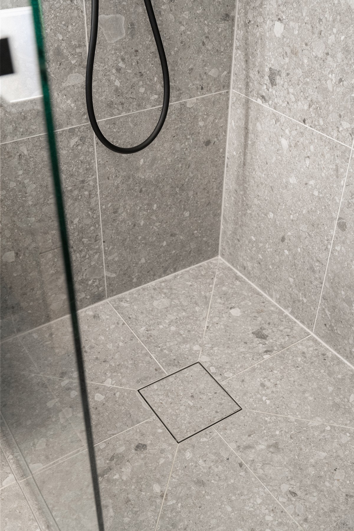 Nedsenket dusjhjørne med herlig flisdetalj og svingbar glassvegg. Videre er dusjhjørnet utstyrt med sluk, regnfallsdusj og termostatstyrt blandebatteri. Galleribilde