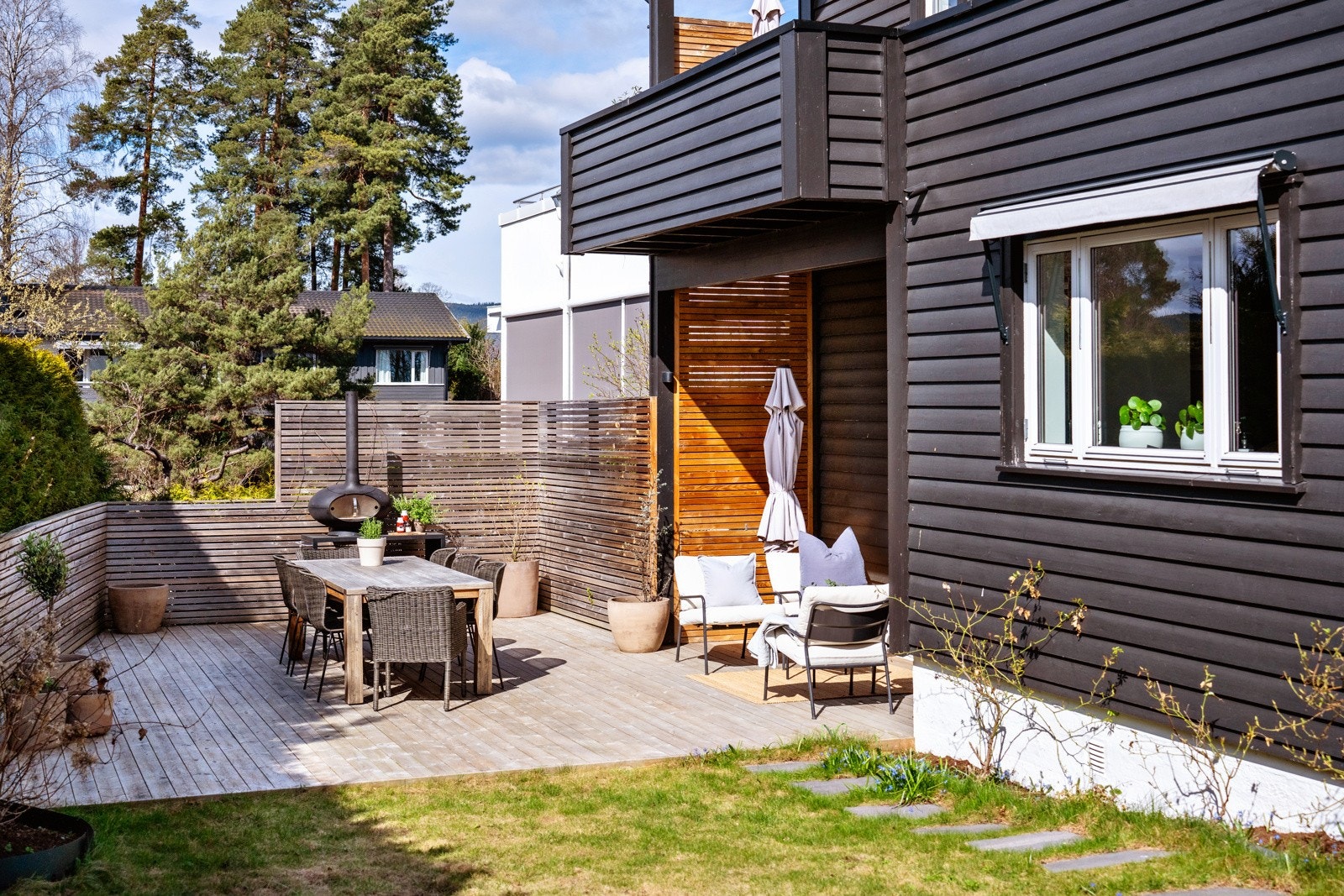 En frodig og grønn hage, omkranset av en vakker og tettvokst hekk, skaper en lun og innbydende atmosfære. Galleribilde