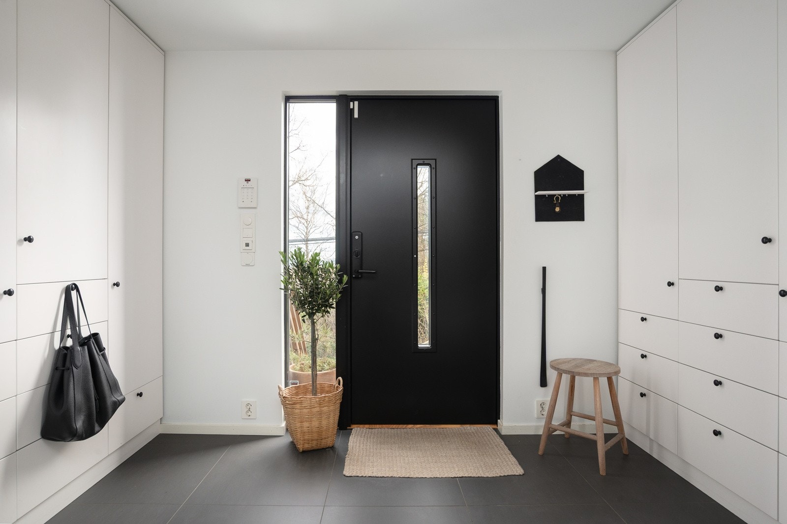 Entreen har rikelig med lagringsplass i et garderobeskap til yttertøy og sko, og det flislagte gulvet gjør det enkelt å holde rommet rent og vedlikeholdsfritt. Galleribilde