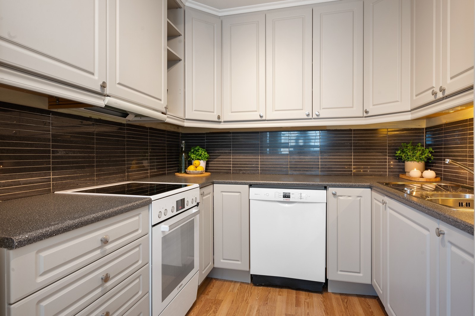 Kjøkkeninnredning som er godt tilpasset rommet - her er det fliser over benken Galleribilde