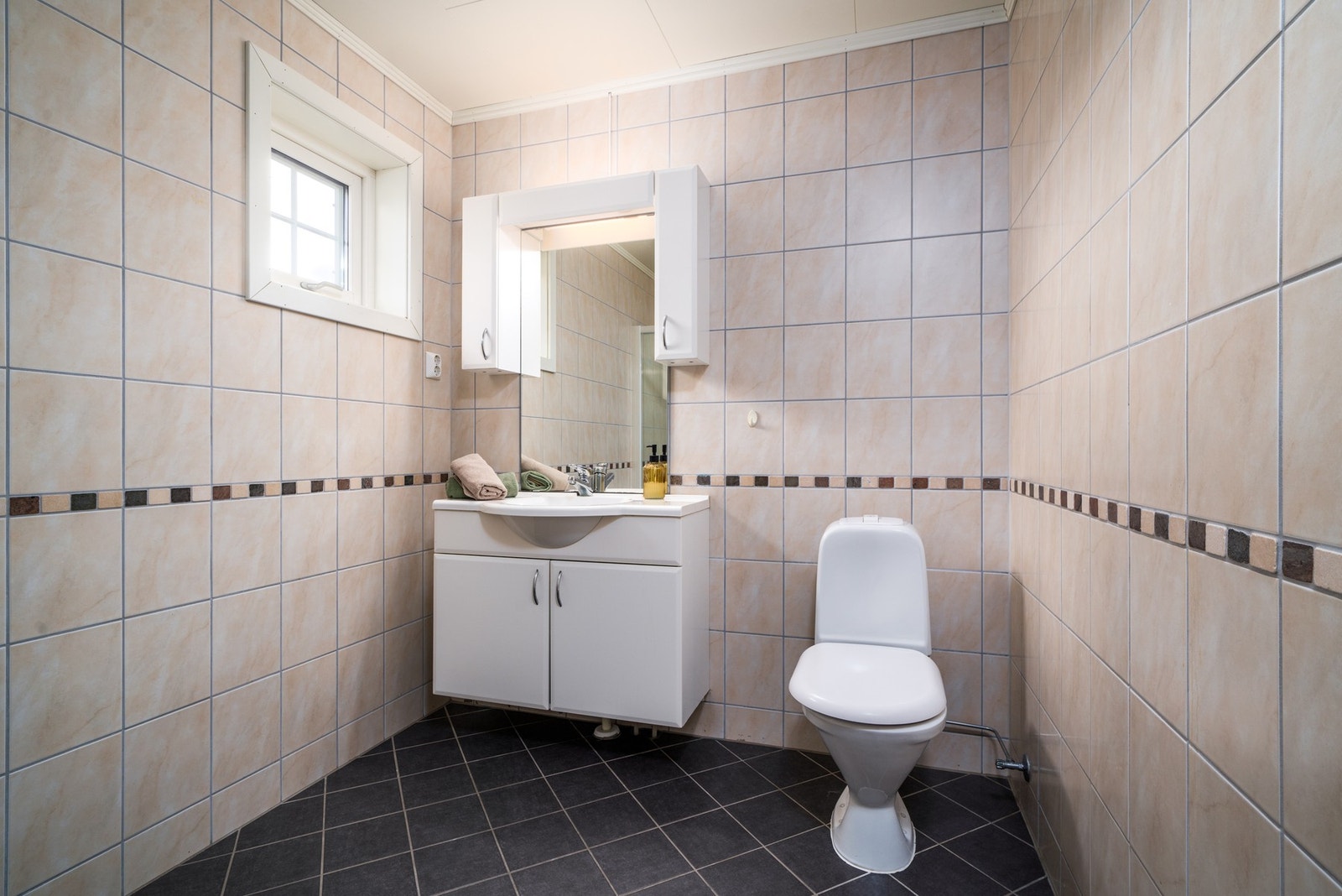 Badet er fra byggeår. Det er flislagt med elektrisk gulvvarme og flislagte vegger. Galleribilde