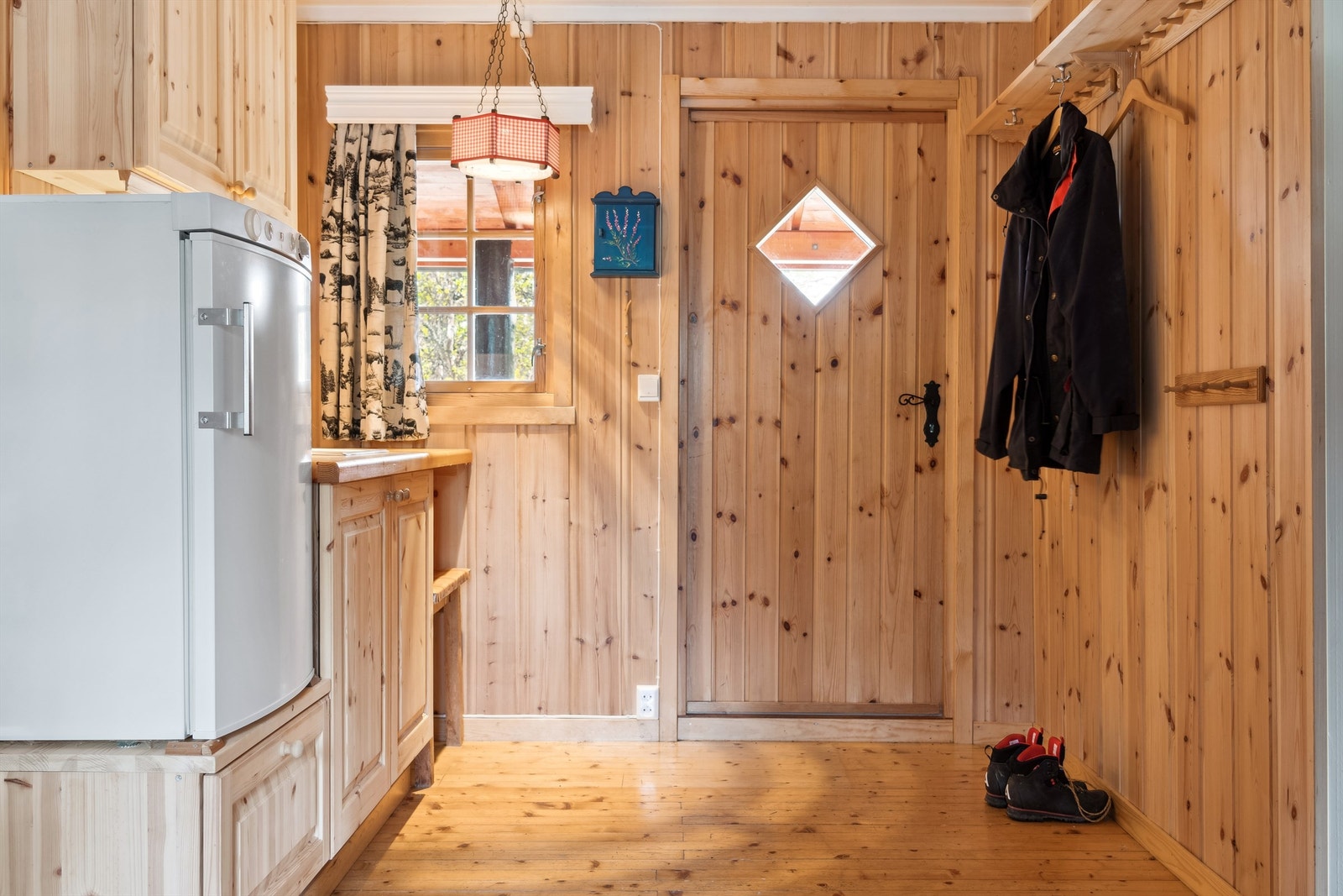 Entréen gir praktisk oppbevaring for yttertøy og direkte tilgang til hyttas hjerte. Galleribilde