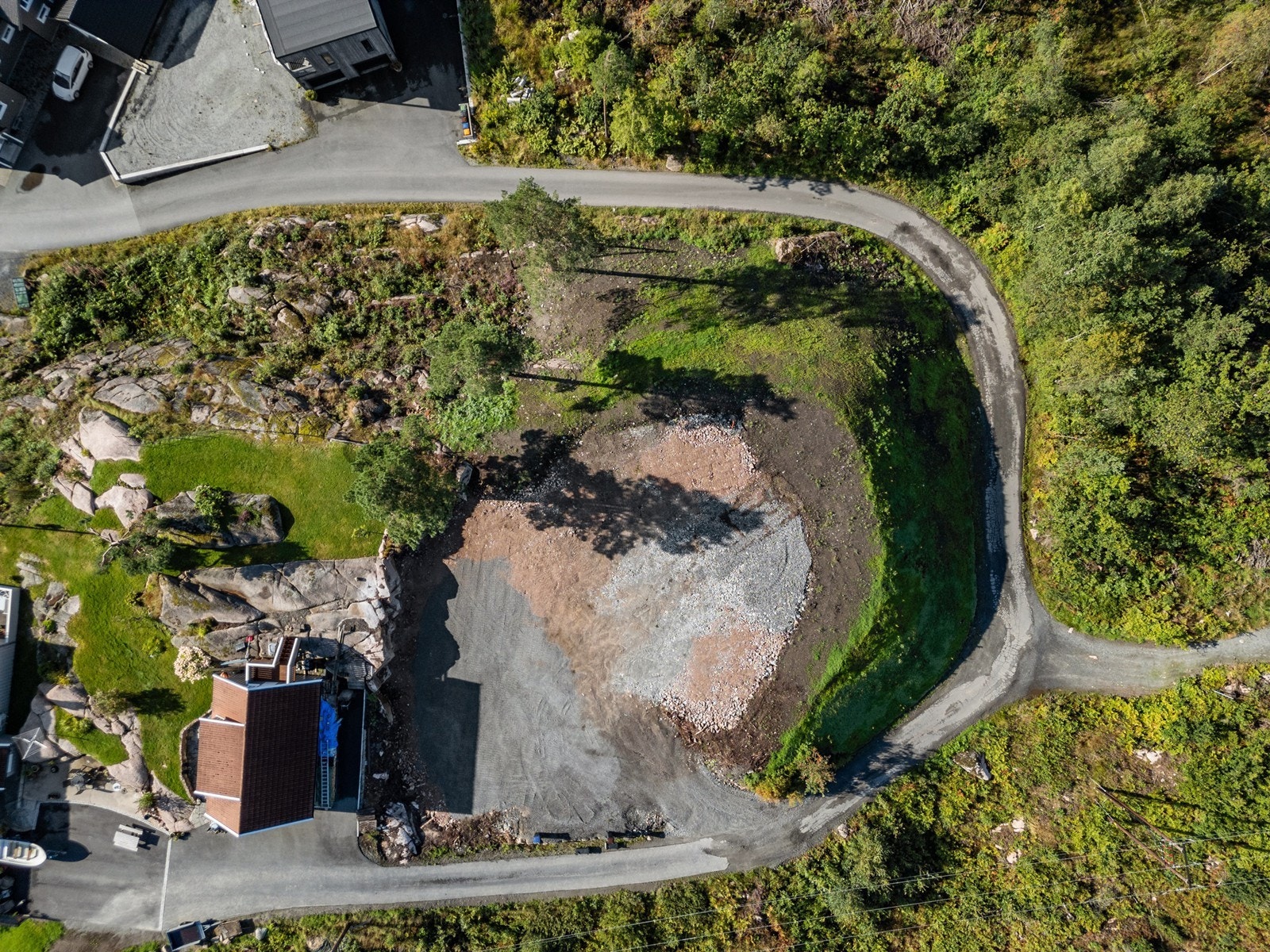 Tomten er planert og det er opparbeidet asfaltert vei frem til tomtegrensen. Galleribilde