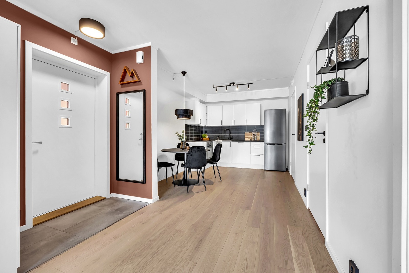 Plassbesparende entré med plass til å ta av seg sko og yttertøy før man beveger seg inn i leiligheten. Galleribilde