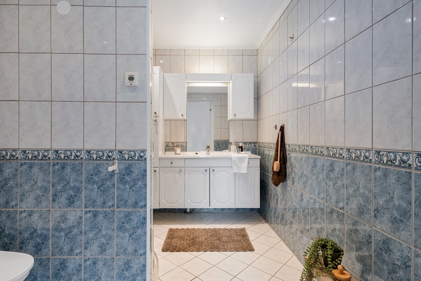 Helfliset lyst bad med varmekabler. Legg merke til downlights i taket Galleribilde