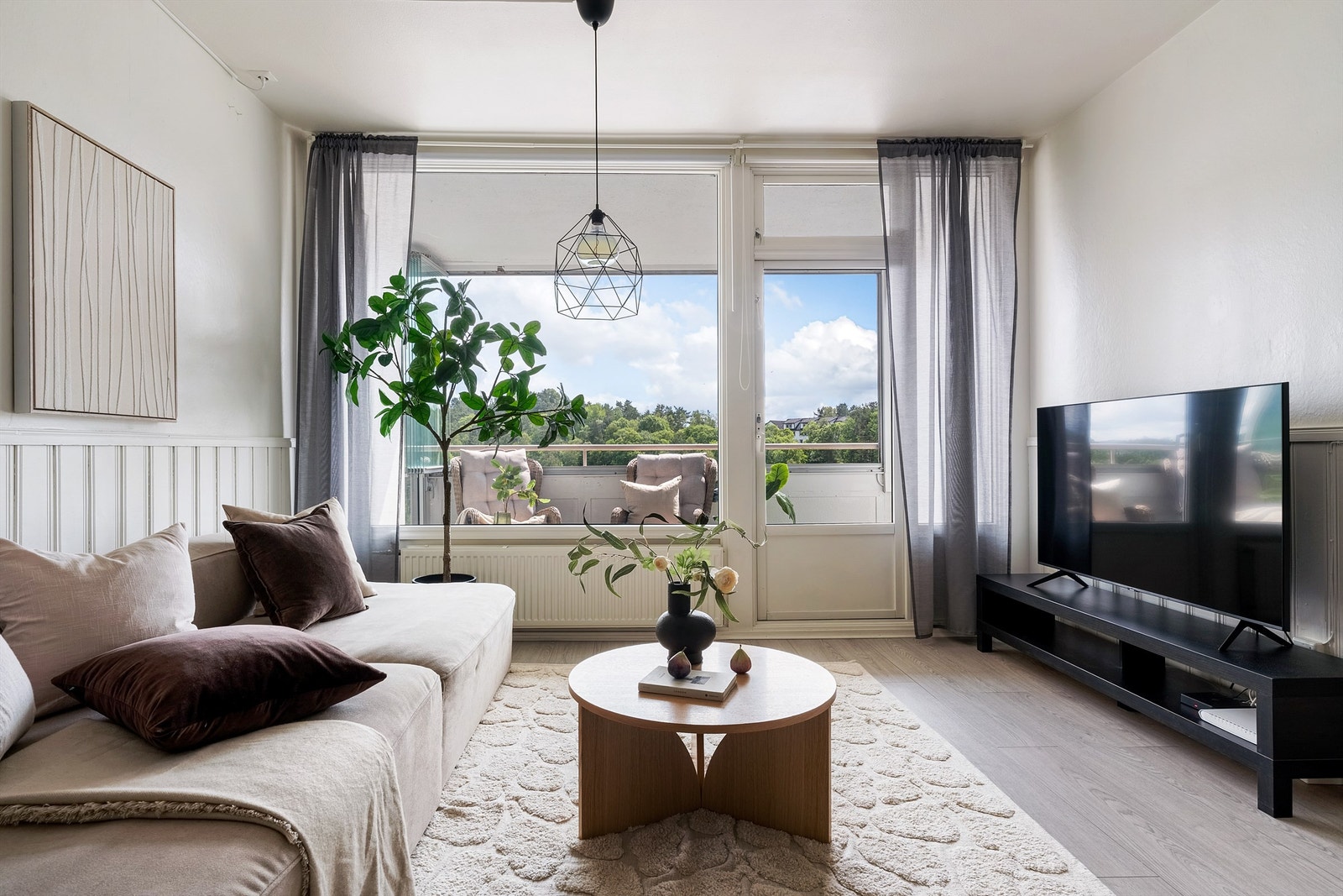 Flott lys stue med store vindusflater som slipper inn rikelig med dagslys Galleribilde