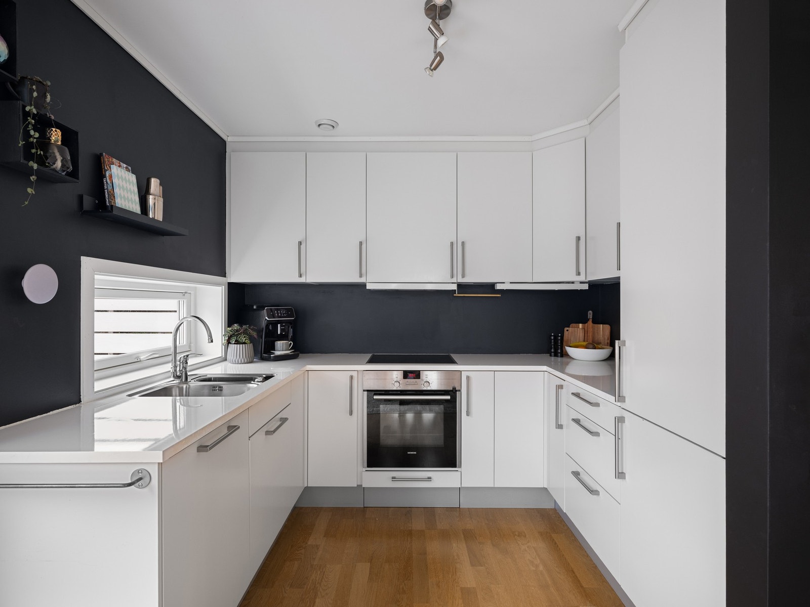 Lyst og pent kjøkken med rikelig med skap og benkeplass Galleribilde