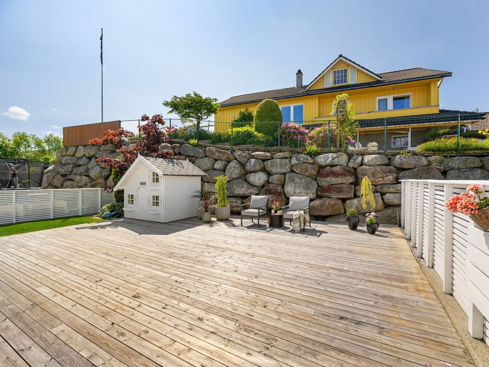 Flott opparbeidet uteområde med stor terrasse og hage Galleribilde