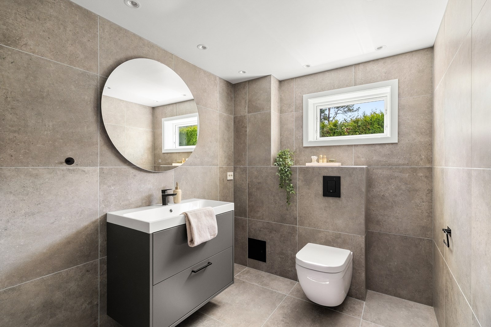 Badet i 1. etasje ble totalrenovert av fagfolk i 2024 og fremstår som delikat og moderne. Her er det 60x60 cm fliser på både gulv og vegger, varmekabler i gulvet og spotter i taket. Galleribilde