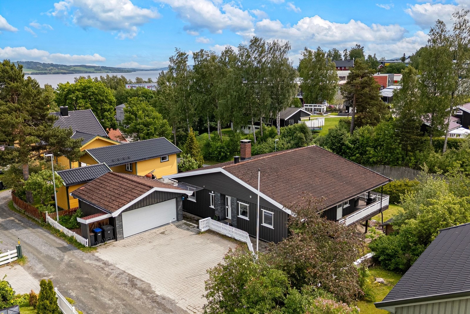 Romslig gårdplass med parkering i dobbelgarasje og steinsatt biloppstilling. Galleribilde