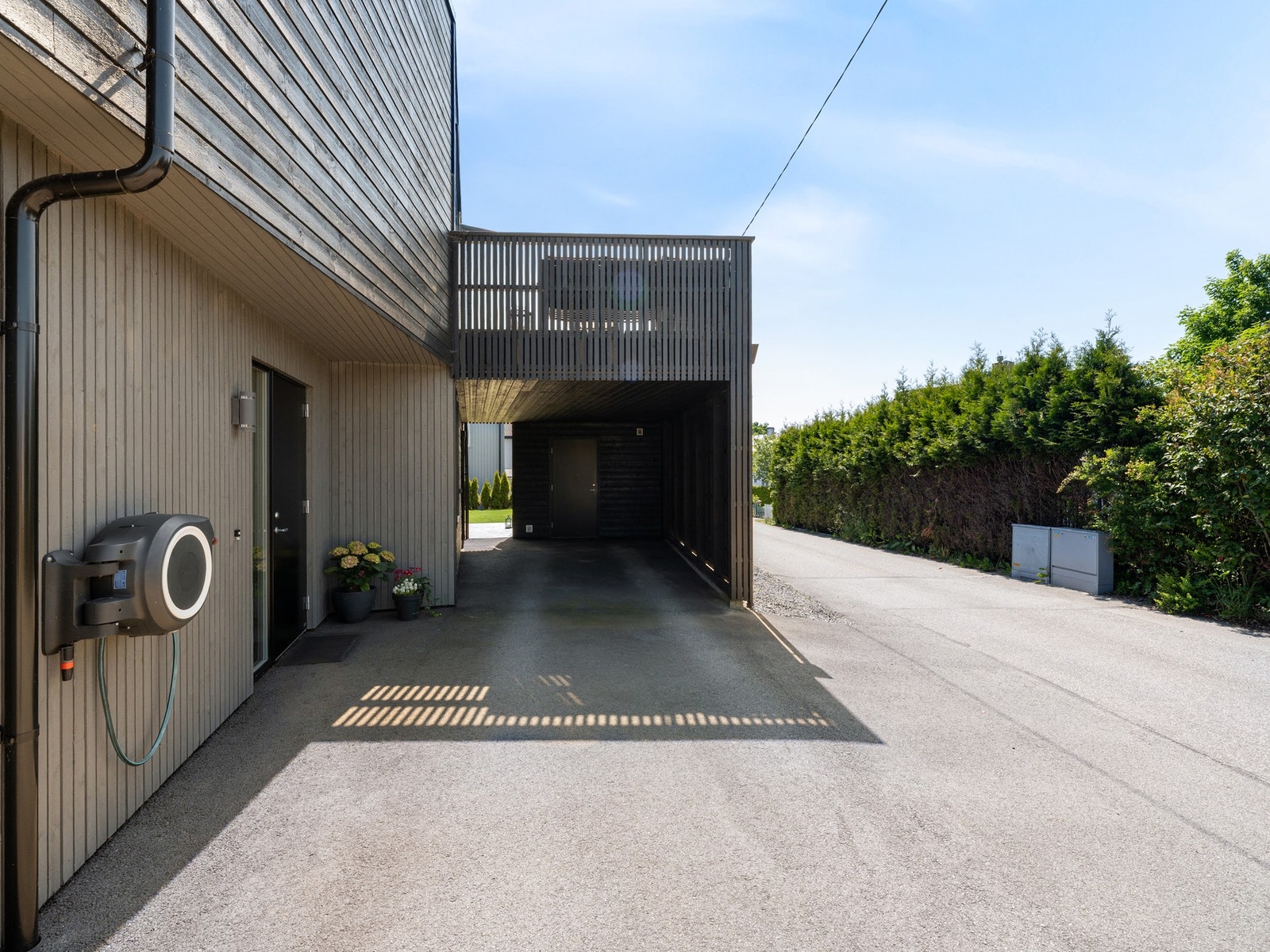 Eiendommen kan ellers by på asfaltert gårdsrom og carport med bod i bakkant Galleribilde