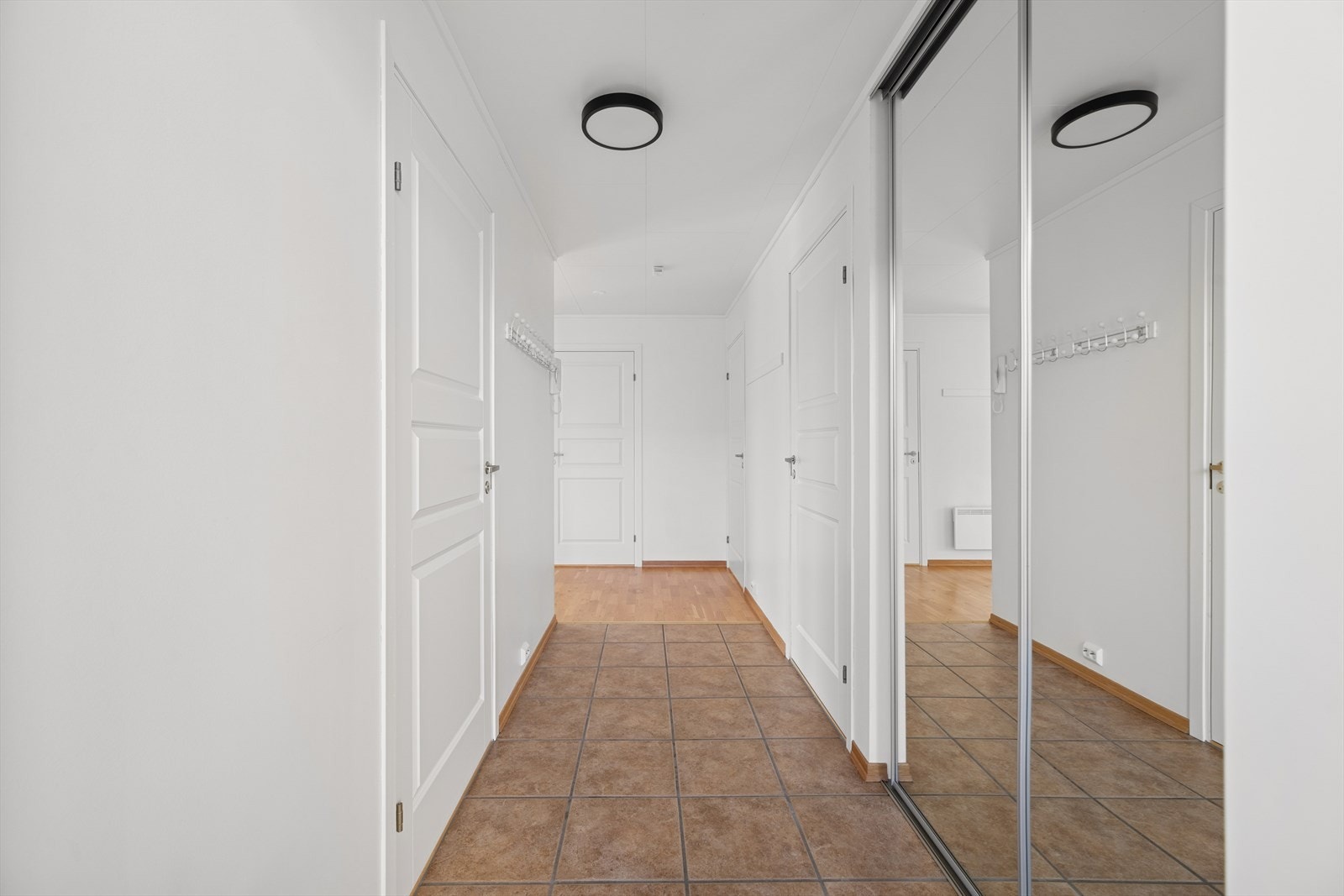 Gangen tilbyr gode oppbevaringmuligheter med en praktisk skyvedørsgarderobe og direkte tilgang til en innvendig bod. Galleribilde